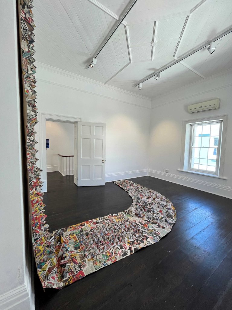 Newspaper installation titled "Amabheqe emihla ngemihla" (2023), featuring variable arrangements of printed material referencing isiZulu petroglyphs and their relevance in everyday life.