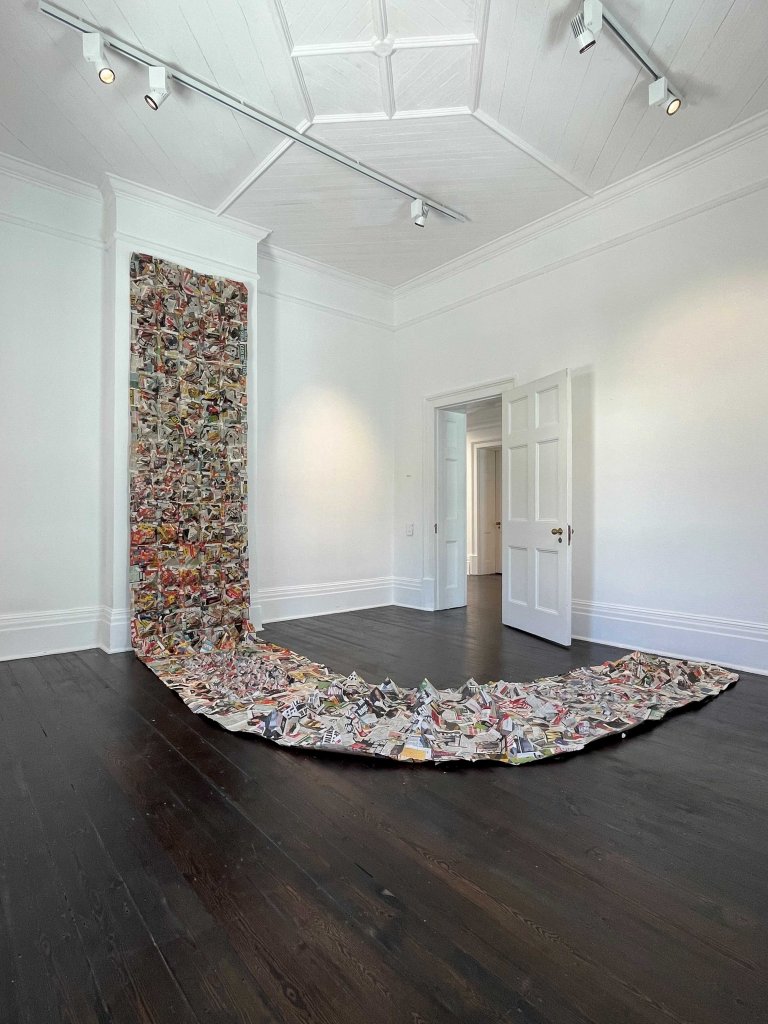 Newspaper installation titled "Amabheqe emihla ngemihla" (2023), featuring variable arrangements of printed material referencing isiZulu petroglyphs and their relevance in everyday life.