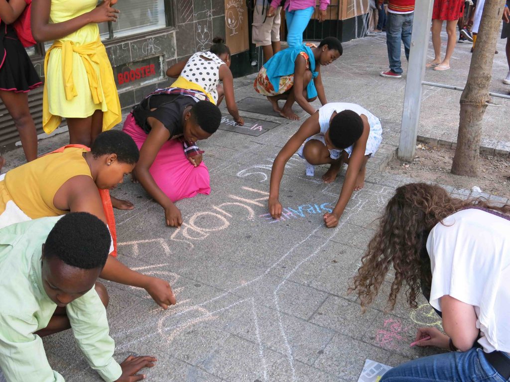 Interactive mural created with chalk, inviting public participation to redraw the city map, challenging apartheid-era spatial divisions in Cape Town.
