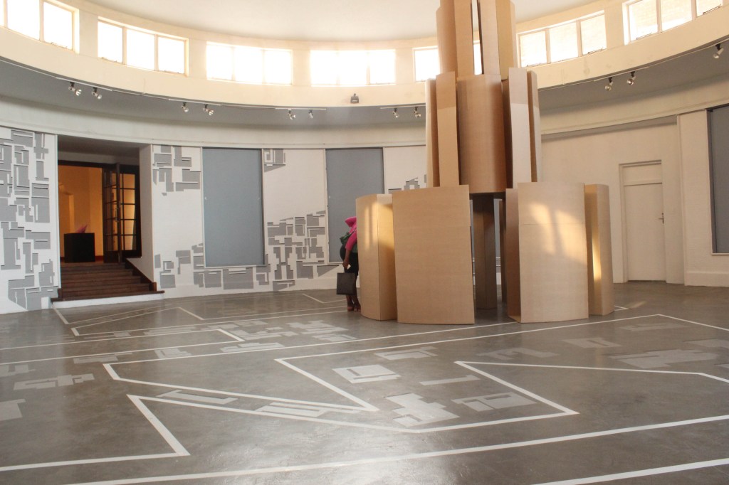Mixed media installation transforming a circular gallery into a navigable sculptural maze inspired by Johannesburg’s urban fabric and graffiti language.