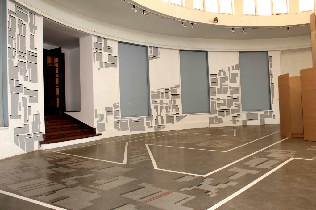 Mixed media installation transforming a circular gallery into a navigable sculptural maze inspired by Johannesburg’s urban fabric and graffiti language.