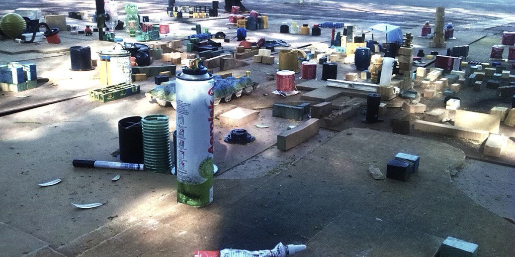 Public installation composed of colourful found objects arranged on a softwood contour map, created during a civic engagement intervention at Vrystaat Kunstefees 2016 in Bloemfontein.