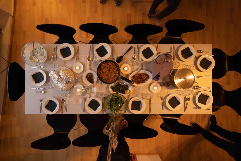 A conceptual dinner table installation with traditional isiZulu vessels and objects, inviting collective knowledge sharing and ancestral dialogue.