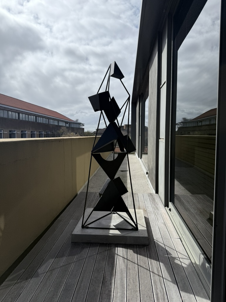 ‘Mcijo qondile’, a contemporary sculpture by Sandile Radebe, inspired by the triangular umcijo motifs found on isiZulu beer vessels. The abstract geometric form engages isiZulu material culture and Indigenous epistemology, exploring connections between community, ancestral worlds, and the evolution of ubuZulu outside colonial frameworks.